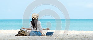 Lifestyle freelance woman relax and sitting meditation on the beach.Â 